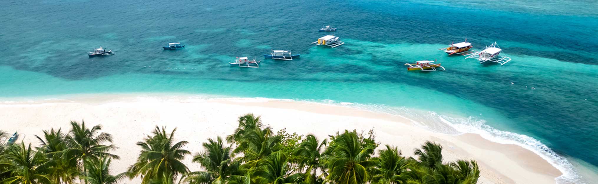 Daku Island, Siargao, Philippines. Tropical beach with palm trees and boats