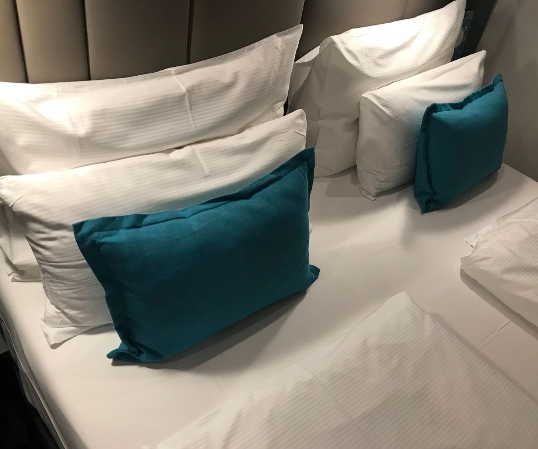 Neat hotel bed with blue pillows