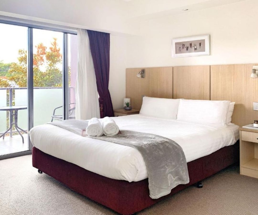 Tidy hotel room with purple curtains