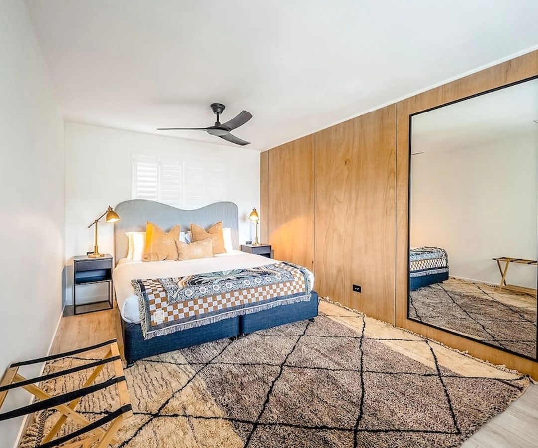 Smart looking hotel room with large bed and mirror