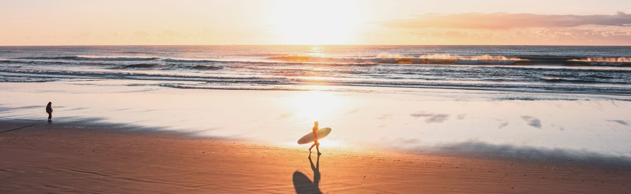 Surfer walking at beach in Byron Bay