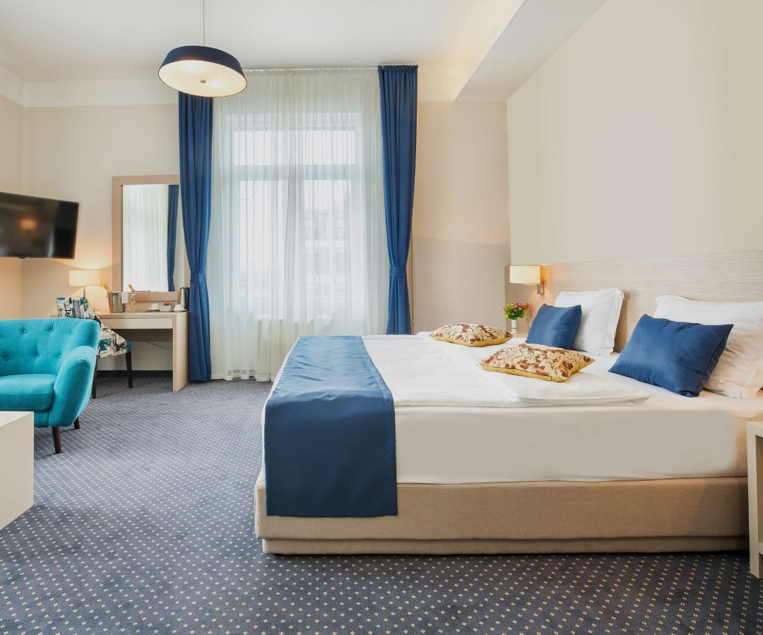 Hotel room with blue curtains and pillows