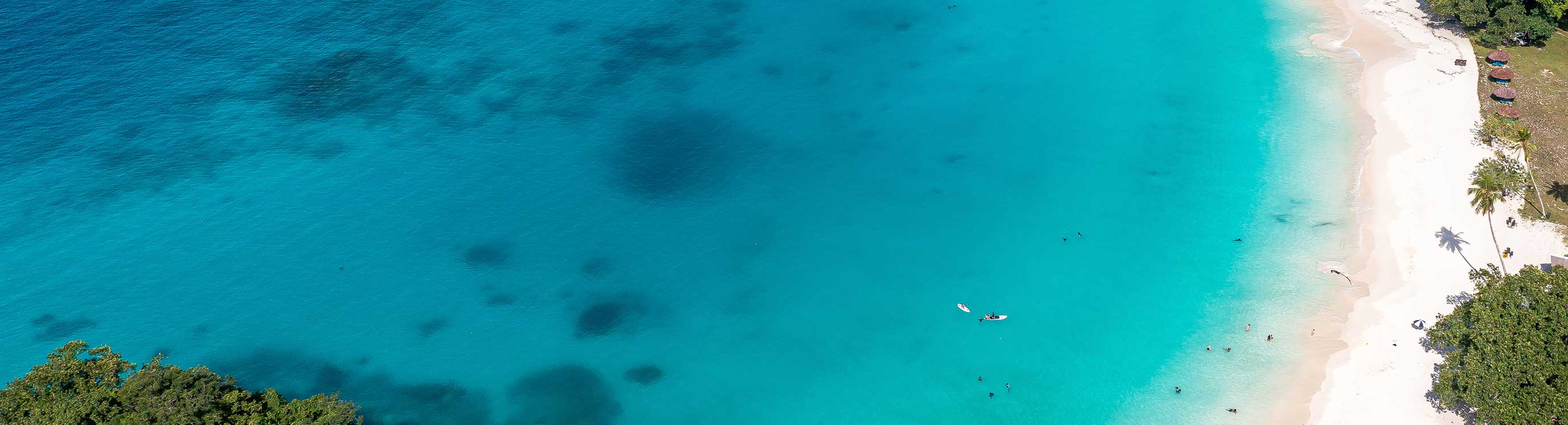 Drone view of sandy beach and green shore near turquoise sea. Tourist settlement. Sanma, Vanuatu.. stock photo