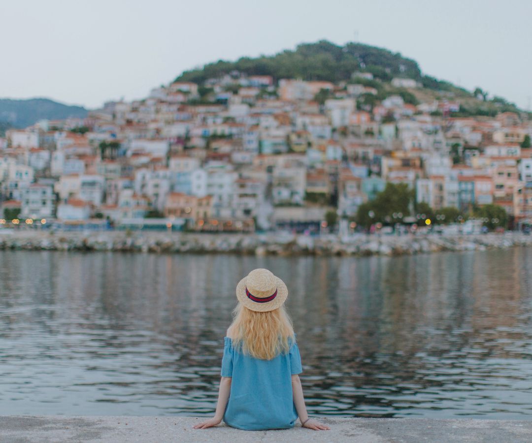 Women sitting next to lake in small town