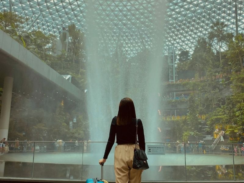 lady in front  of the Jewel Changi Rain Vortex