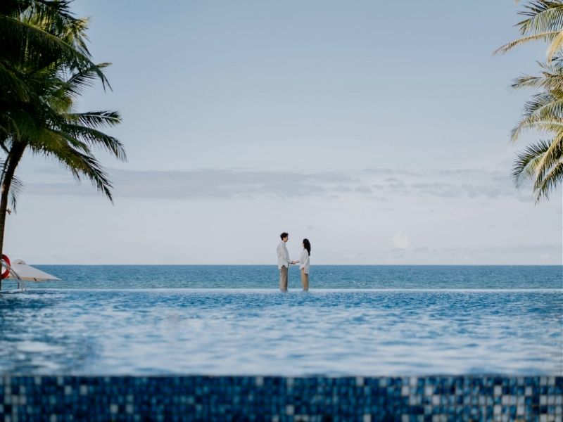 couple standing on infinity pool