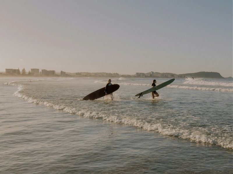 couple of surfers going into the water