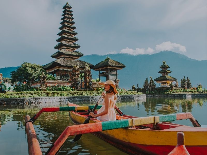 women on canoe bali temple