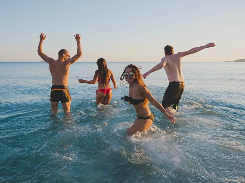 friends running into ocean