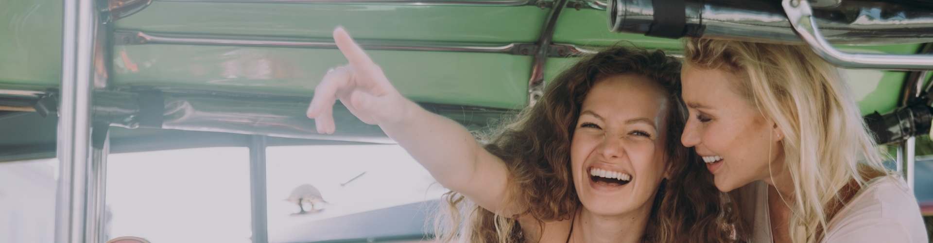 friends smiling on a tuktuk in thailand
